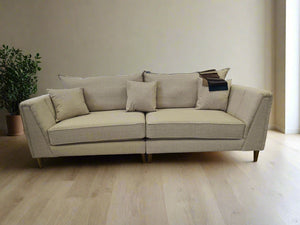 Beige sofa in a showroom with chairs and tables around