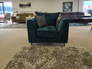 Living room with green armchair, coffee table, and couches.