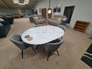 Dining area with a marble effect table and gray chairs in a living room setting.